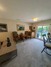 Living room with a textured ceiling and carpet flooring