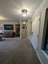 Hall with a textured ceiling and carpet