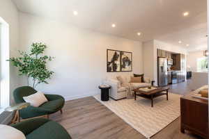 Living area with wood finished floors and recessed lighting