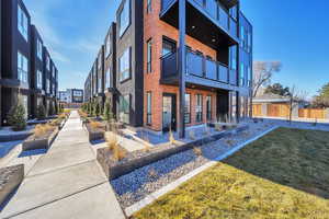Back of house with brick siding and a balcony