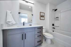 Bathroom featuring vanity, light tile patterned flooring, and washtub / shower combination