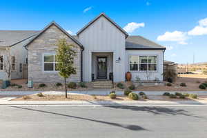 View of front of house featuring board and batten siding and stone siding