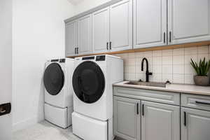 Washroom featuring washing machine and clothes dryer and cabinet space