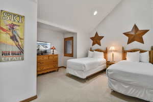 Bedroom with carpet flooring and lofted ceiling