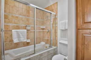 Bathroom featuring tiled shower / bath and toilet