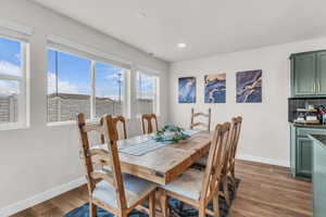 Dining area with dark wood-style floors and recessed lighting