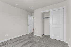 Unfurnished bedroom featuring carpet and a closet