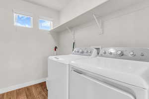 Washroom featuring wood finished floors and washing machine and dryer