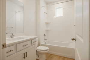 Bathroom with vanity, shower / bath combination, and light wood-style flooring