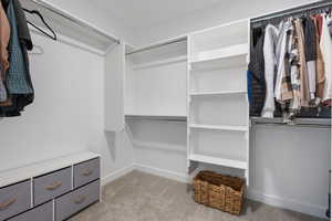 Walk in closet with light colored carpet