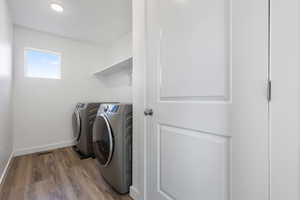 Washroom featuring dark wood-style floors, washer and dryer, and recessed lighting