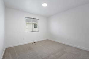 Carpeted empty room featuring baseboards