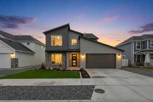 Contemporary home with driveway, stone siding, and a garage