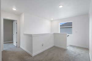 Spare room featuring light colored carpet and recessed lighting