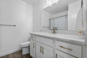Bathroom featuring a shower with curtain, vanity, and dark wood-style floors