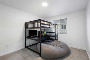 Bedroom with an office area and light carpet