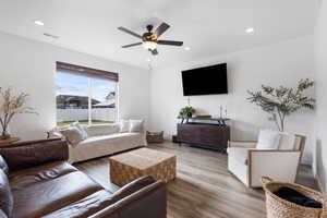 Living area with wood finished floors, recessed lighting, and a ceiling fan