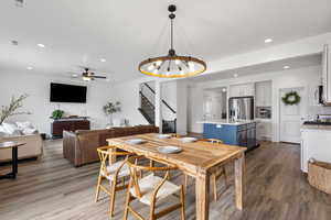 Dining area featuring stairs, recessed lighting, a chandelier, dark wood-type flooring, and a ceiling fan