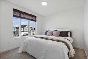 Carpeted bedroom featuring baseboards and a residential view