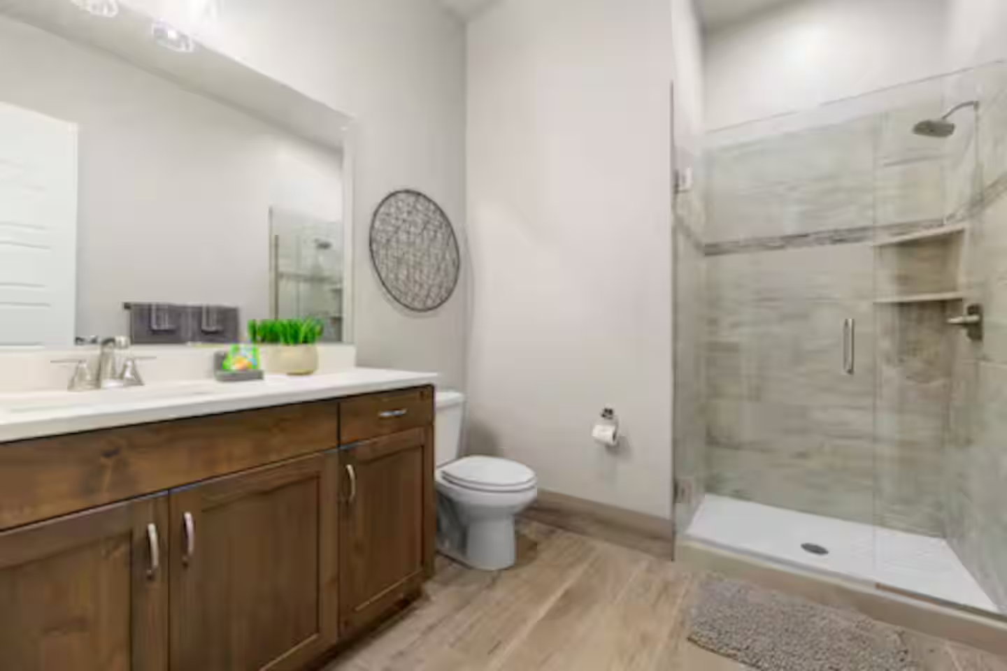 Full bath featuring vanity, a shower stall, and light wood-style flooring