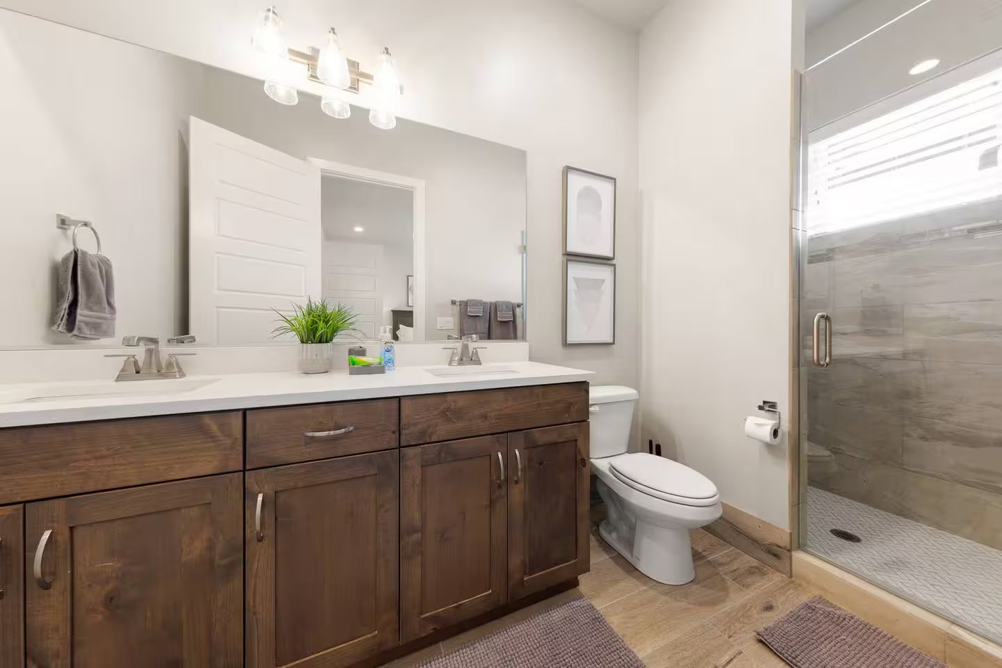 Full bathroom with double vanity and a shower stall