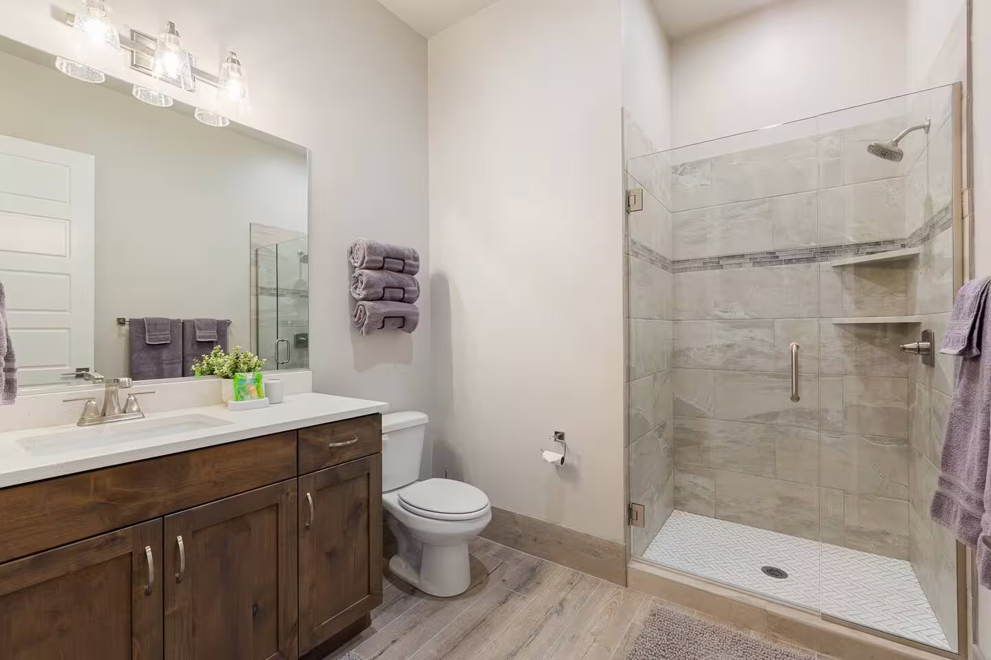 Bathroom featuring light wood-style flooring, vanity, and a stall shower