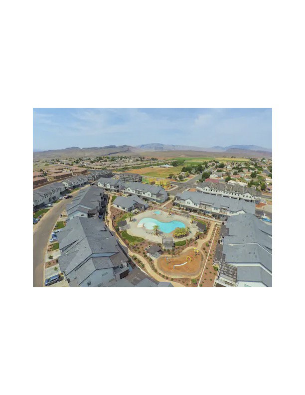 Aerial perspective of suburban area featuring a mountainous background and a pool area