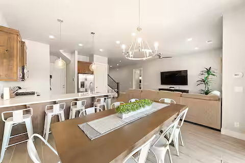 Dining space with a chandelier, stairs, light wood-style floors, and recessed lighting