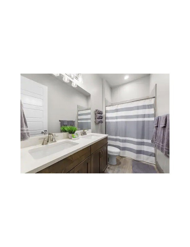 Bathroom with a shower with curtain and double vanity
