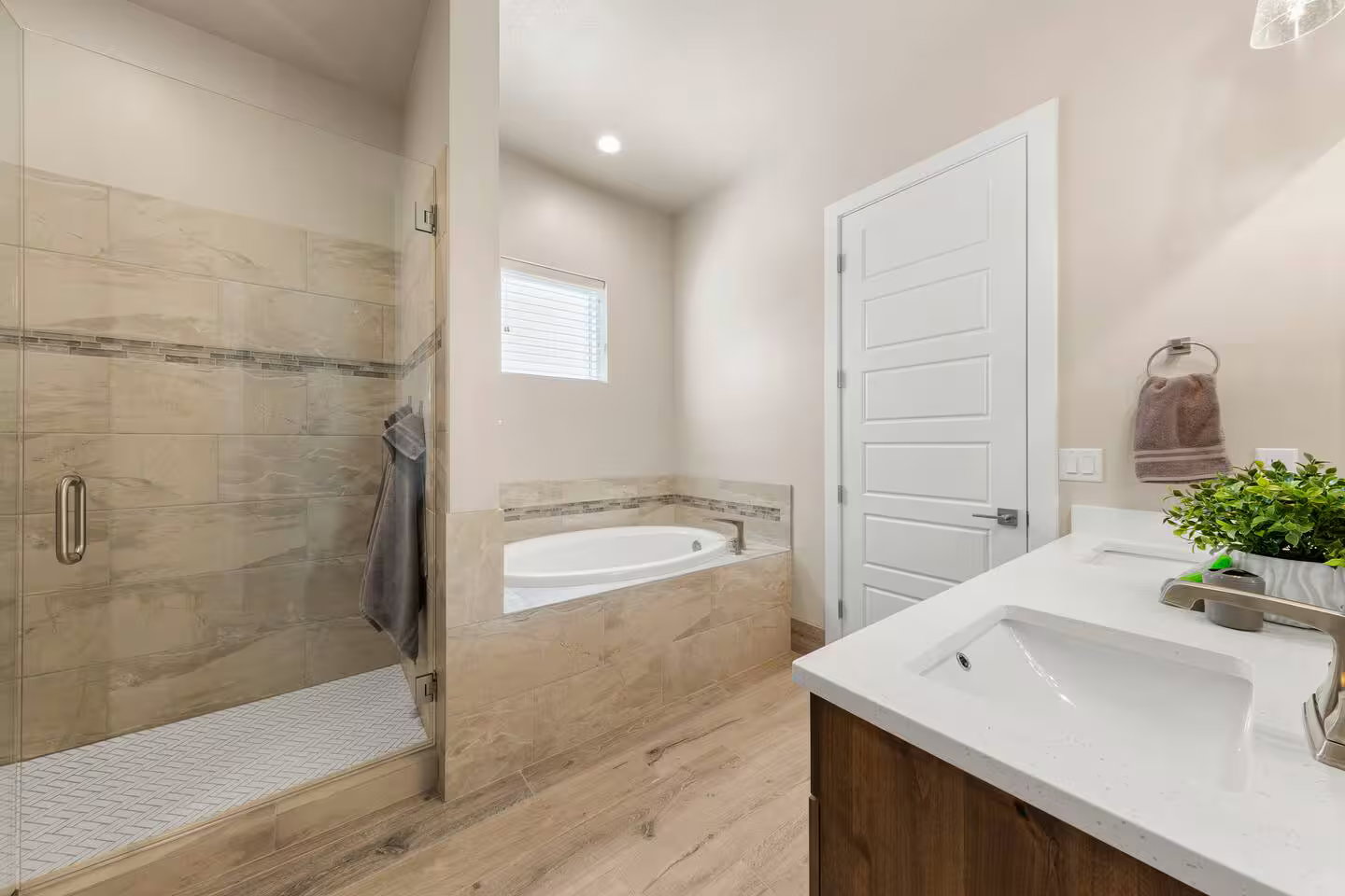 Full bath with a bath, a shower stall, double vanity, and light wood-style flooring
