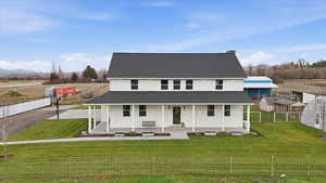 View of front facade with covered porch and a shingled roof