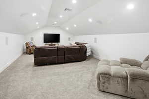 Cinema room featuring light carpet, recessed lighting, and lofted ceiling
