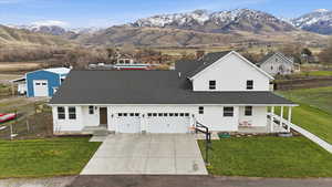 View of front facade with a front lawn, a mountain view, driveway, and covered porch