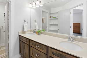 Full bathroom with double vanity and a shower