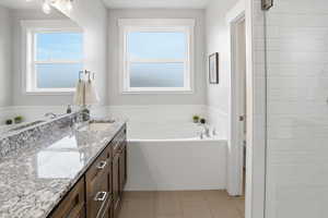 Ensuite Full bathroom with vanity, a bath, double headed tiled shower and light tile patterned flooring