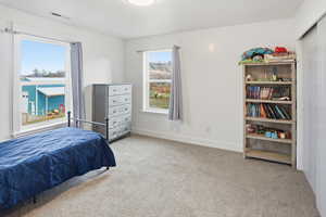 Bedroom with light colored carpet and baseboards