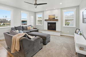 Carpeted living area with a fireplace, recessed lighting, and ceiling fan