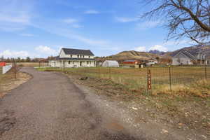 View of asphalt road featuring a mountain view and a view of countryside