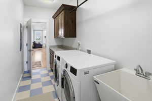 Laundry area featuring light flooring, washing machine and dryer, and cabinet space