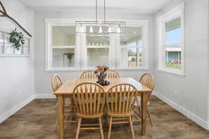 Dining area with dark wood-style floors and baseboards
