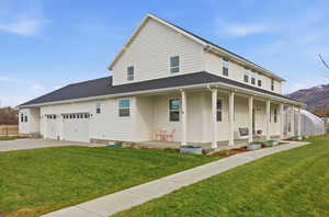 View of front of house with a front lawn, a large porch, concrete driveway, and an attached 3 car garage
