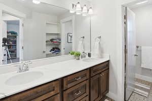 Bathroom featuring a walk in closet and double vanity