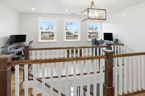 Office loft area with a chandelier