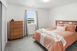 Bedroom featuring light colored carpet and a closet