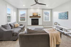Living area featuring carpet, ceiling fan, recessed lighting, plenty of natural light, and a fireplace