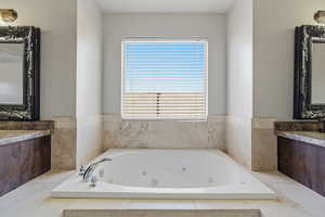 Full bathroom featuring vanity and a tub with jets
