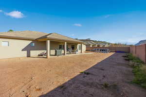 Back of property featuring stucco siding, a fenced backyard, and a patio area