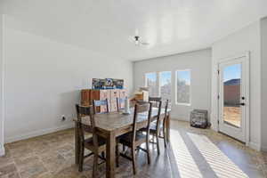 Dining room featuring a textured ceiling and stone finish floors