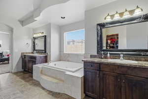 Full bathroom with a bath, two vanities, and ensuite bath