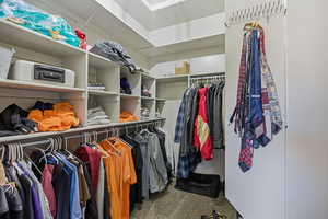 Spacious closet featuring dark colored carpet and attic access